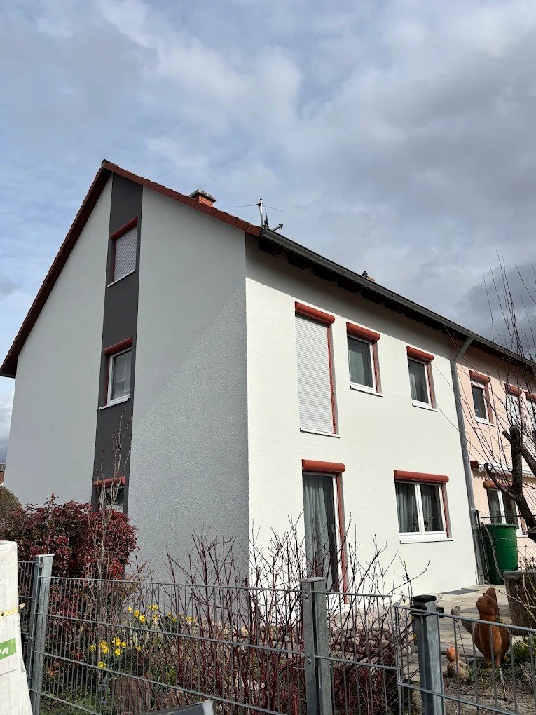 Frisch sanierte Fassade eines Wohnhauses in Weiß und Anthrazit